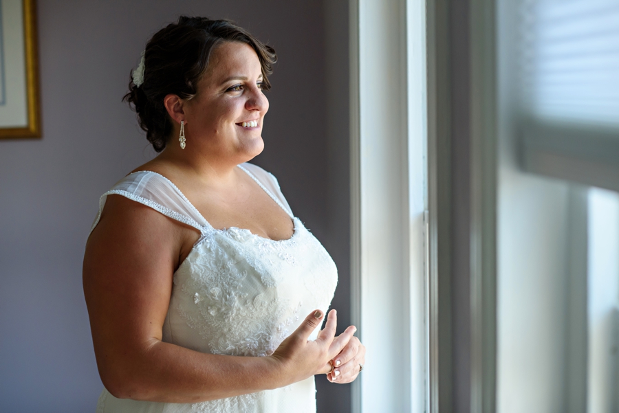 A beautiful bride looking out the window before the wedding ceremony.